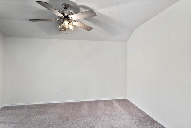 carpeted spare room with vaulted ceiling, ceiling fan, and a textured ceiling