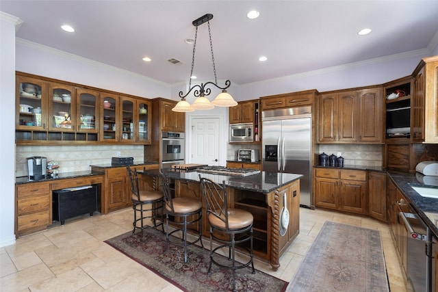 kitchen with built in appliances, dark stone counters, light tile patterned flooring, a center island, and backsplash