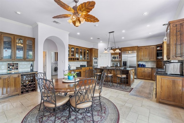 dining area featuring visible vents, crown molding, washer / dryer, recessed lighting, and arched walkways