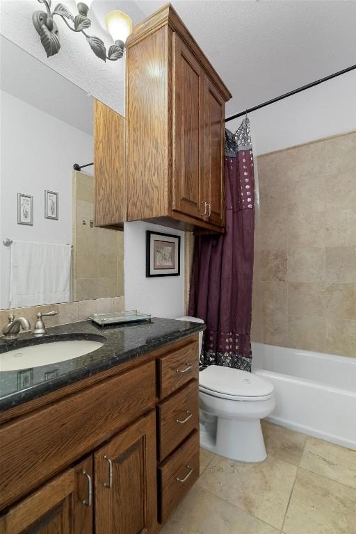 bathroom with vanity, tile patterned floors, shower / tub combo, and toilet