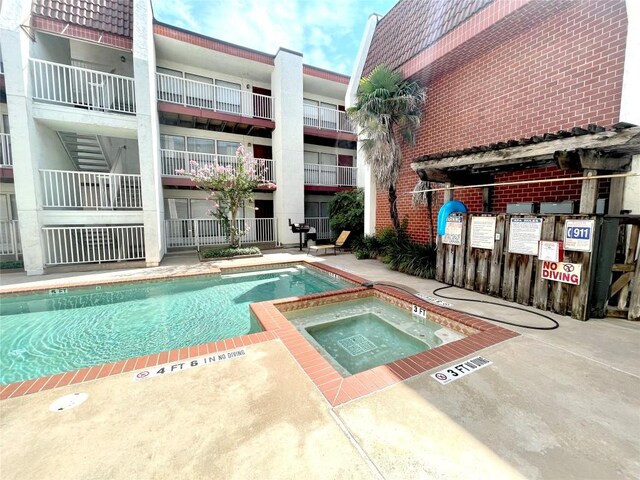 view of swimming pool with a community hot tub