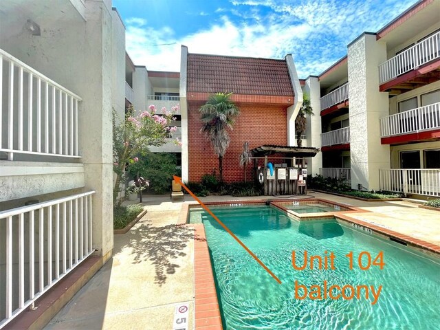 view of pool with a hot tub