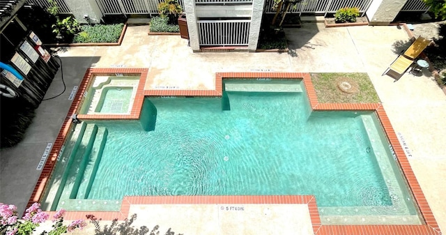 view of swimming pool with an in ground hot tub