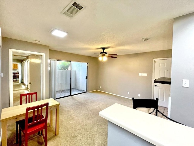 carpeted living room featuring a textured ceiling and ceiling fan