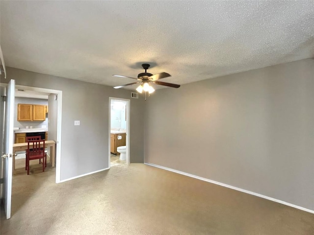 carpeted spare room featuring a textured ceiling and ceiling fan