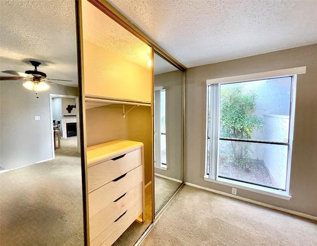 interior space featuring light colored carpet and ceiling fan