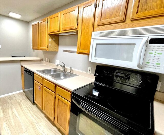 kitchen with sink, light hardwood / wood-style flooring, and black appliances