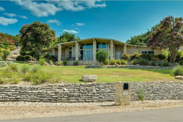 view of front of home with stone siding and a front yard