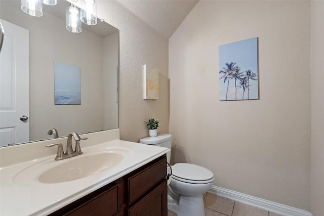 bathroom with tile patterned floors, vanity, vaulted ceiling, and toilet