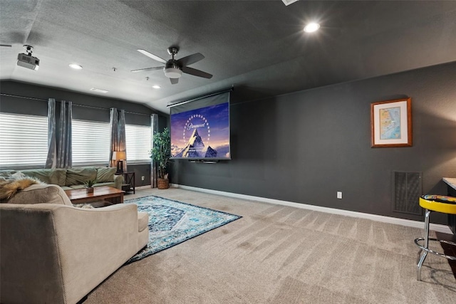 cinema room featuring ceiling fan, lofted ceiling, a textured ceiling, and carpet floors