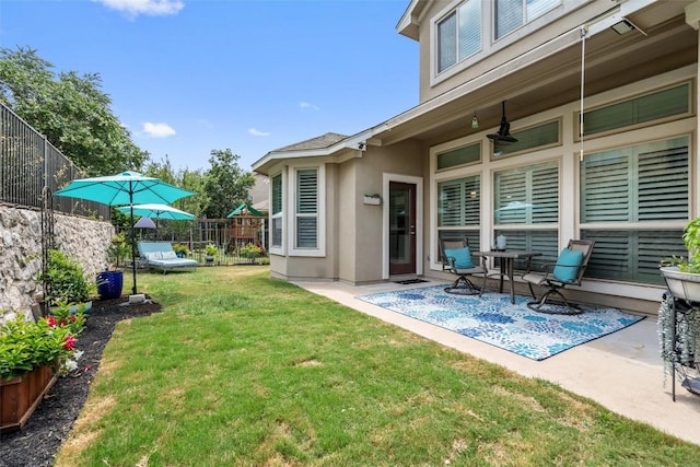 view of yard with ceiling fan and a patio