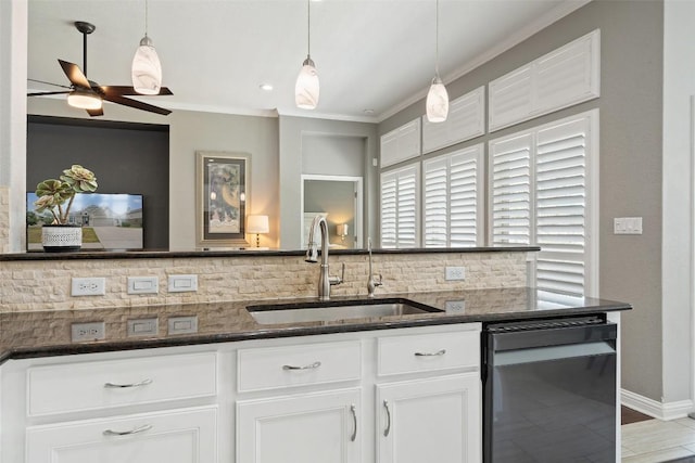 kitchen featuring sink, tasteful backsplash, dark stone countertops, pendant lighting, and white cabinets