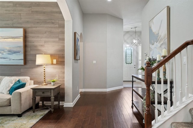 entrance foyer with wood walls and dark hardwood / wood-style flooring