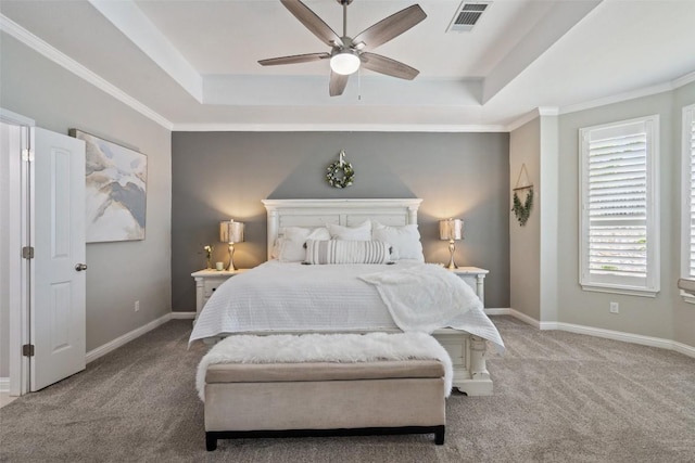 bedroom with a tray ceiling, ceiling fan, crown molding, and carpet