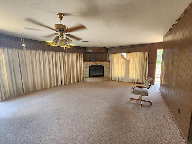 unfurnished room with light colored carpet, ceiling fan, and wood walls