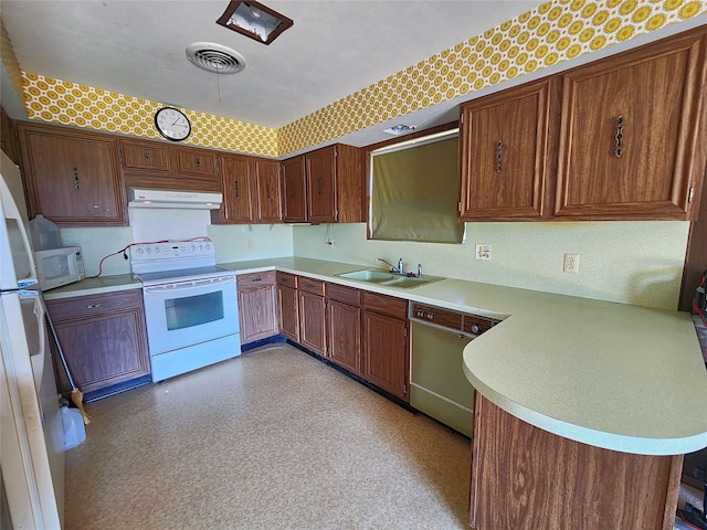 kitchen featuring range hood, sink, white appliances, and kitchen peninsula