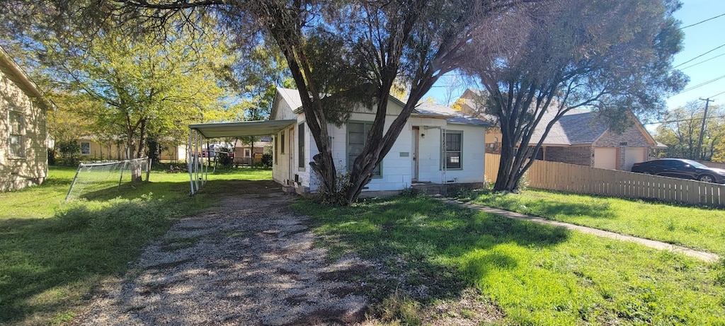 view of front of property with a carport and a front lawn