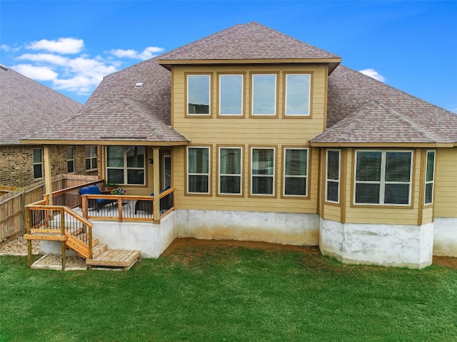 rear view of house with a lawn and a wooden deck