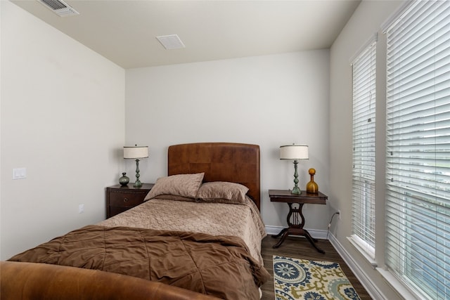 bedroom featuring dark hardwood / wood-style floors and multiple windows