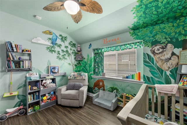 bedroom featuring a nursery area, lofted ceiling, hardwood / wood-style floors, and ceiling fan