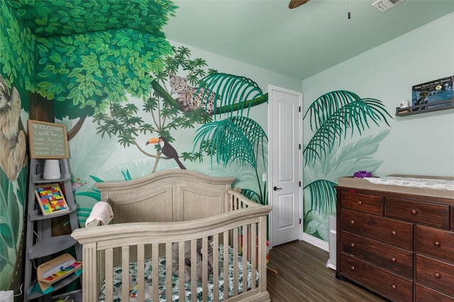 bedroom featuring dark hardwood / wood-style flooring and a nursery area