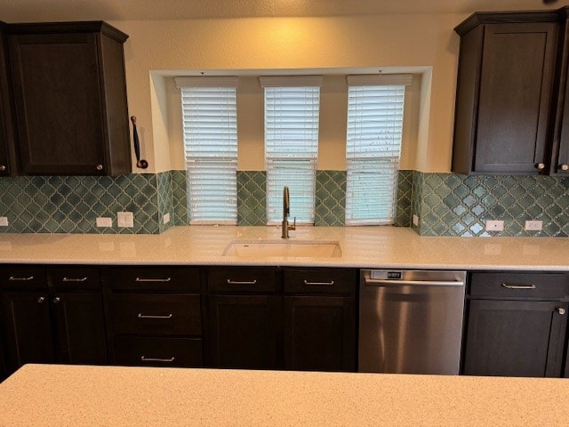 kitchen featuring backsplash, dark brown cabinets, sink, and stainless steel dishwasher