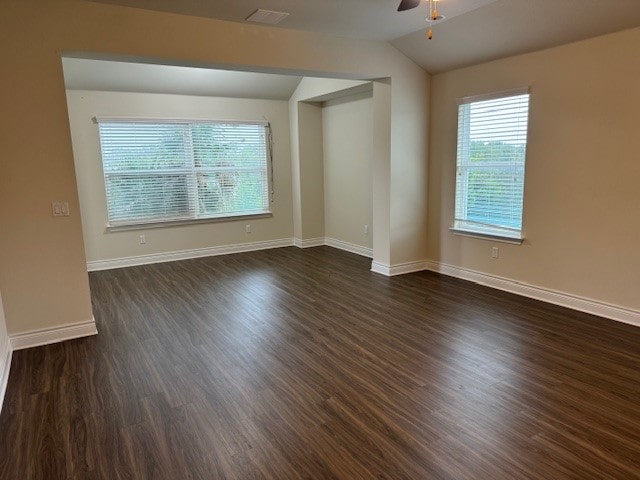 spare room with ceiling fan, dark hardwood / wood-style flooring, and vaulted ceiling