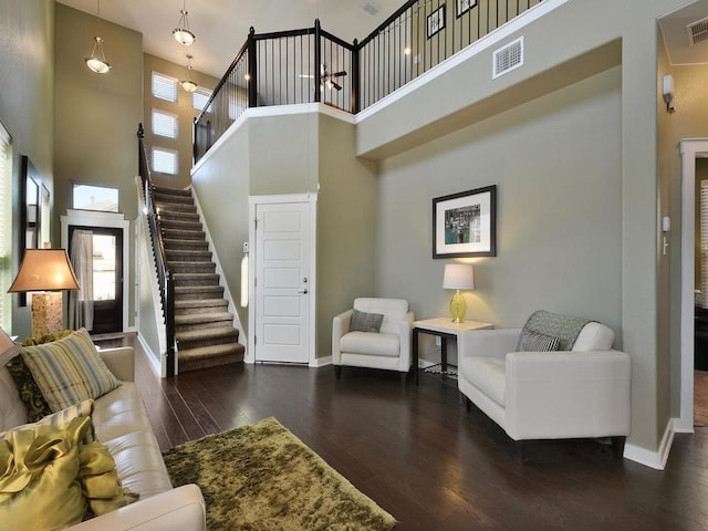 living room featuring dark hardwood / wood-style floors and a high ceiling