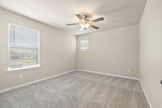 carpeted empty room with plenty of natural light and ceiling fan