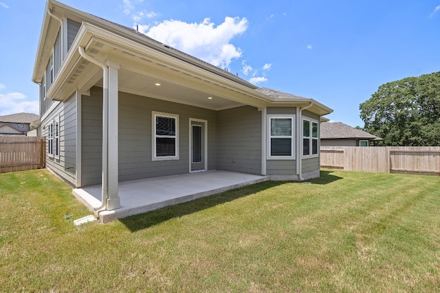 back of house with a patio and a yard