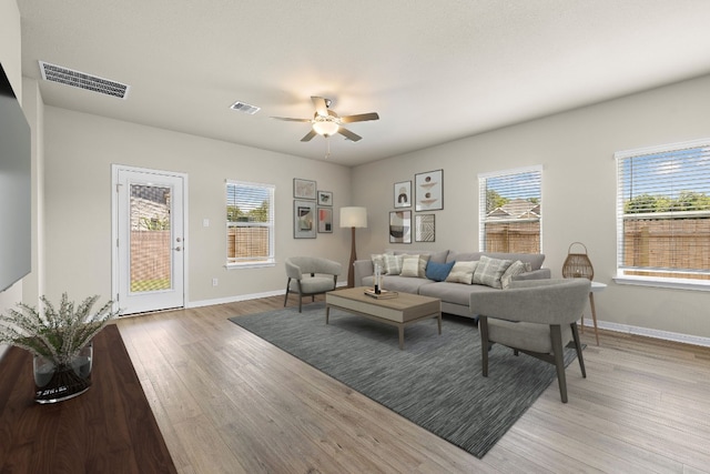 living room featuring a wealth of natural light, light hardwood / wood-style flooring, and ceiling fan