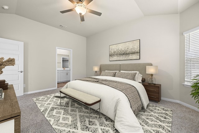 carpeted bedroom with ceiling fan, vaulted ceiling, and ensuite bath