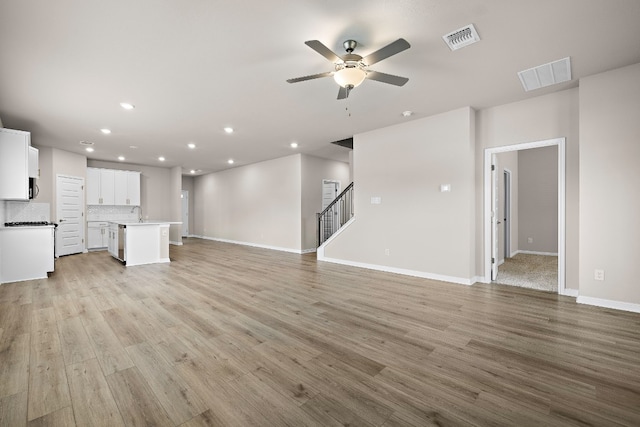 unfurnished living room with ceiling fan and light hardwood / wood-style floors