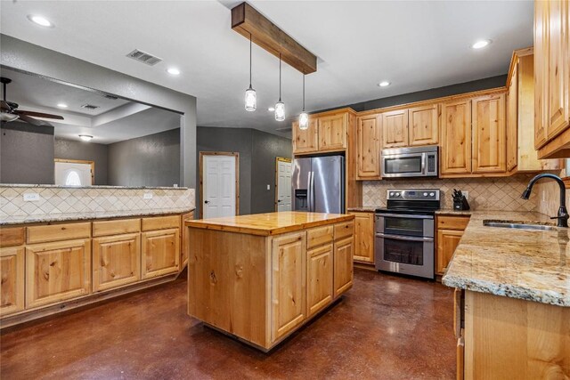 kitchen featuring backsplash, a center island, ceiling fan, stainless steel appliances, and sink