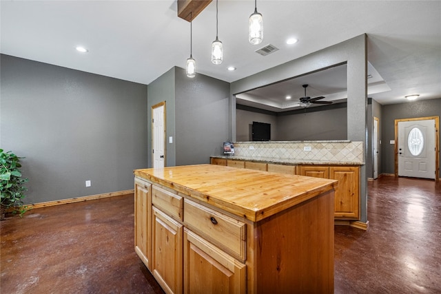 kitchen featuring backsplash, a kitchen island, ceiling fan, decorative light fixtures, and butcher block countertops