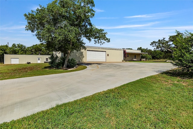 ranch-style house with a garage, an outdoor structure, and a front yard