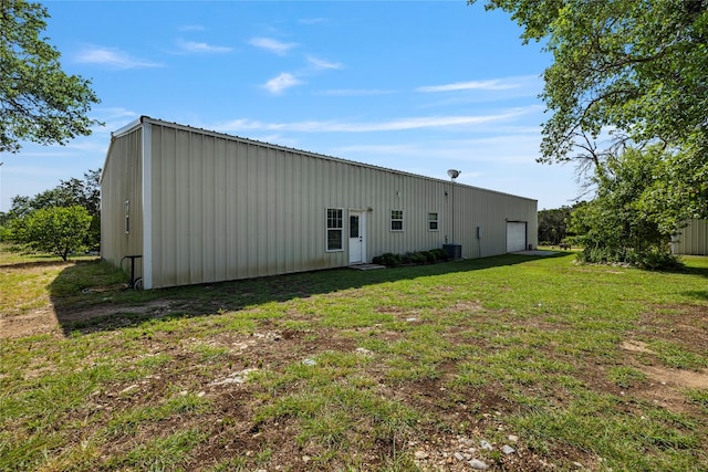 back of property featuring a garage and a yard