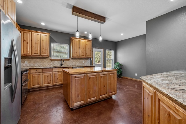 kitchen featuring pendant lighting, decorative backsplash, sink, a kitchen island, and stainless steel fridge