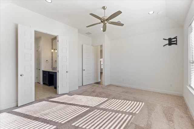 unfurnished bedroom featuring light carpet, multiple windows, lofted ceiling, and ceiling fan