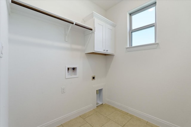 laundry room featuring electric dryer hookup, cabinets, light tile patterned floors, and washer hookup