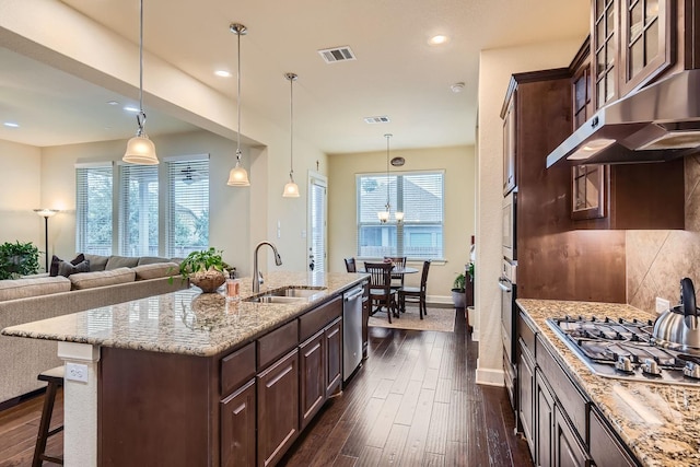 kitchen featuring dark brown cabinetry, appliances with stainless steel finishes, sink, hanging light fixtures, and dark hardwood / wood-style floors