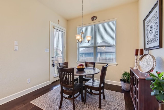 dining room featuring a chandelier, dark wood-style floors, a wealth of natural light, and baseboards