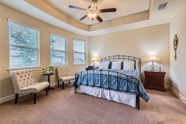 bedroom featuring ceiling fan, carpet floors, and a raised ceiling