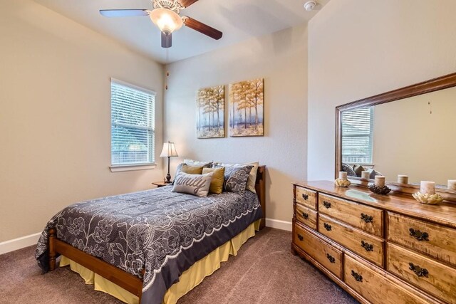 bedroom with ceiling fan and dark carpet