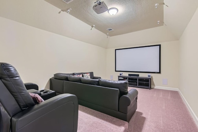 home theater featuring visible vents, baseboards, light colored carpet, lofted ceiling, and a textured ceiling