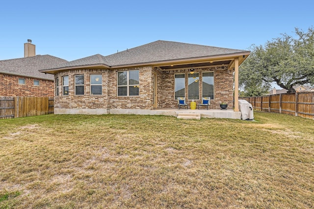 back of house with a yard and a patio