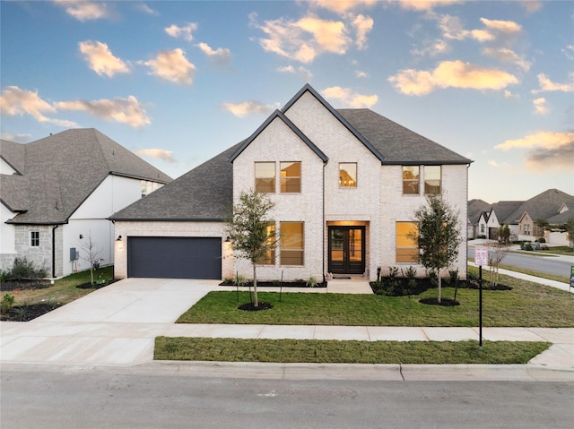 french country style house with a front lawn and a garage