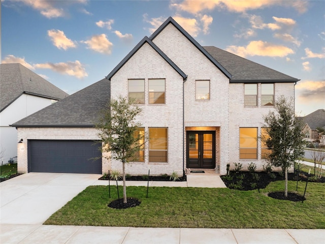 view of front of property with a garage and a lawn