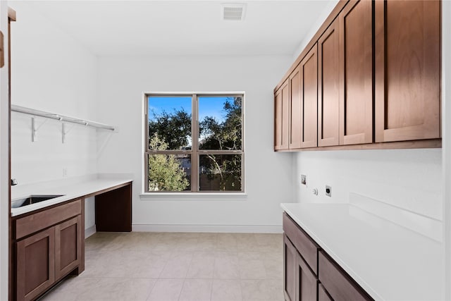 clothes washing area featuring sink, hookup for an electric dryer, and cabinets