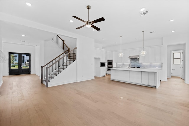 unfurnished living room with ceiling fan and light wood-type flooring